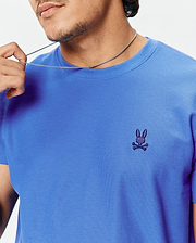 Mens Taylor Pique Tee, vibrant blue classic fit with a visible pique texture, featuring a small dark indigo embroidered Psycho Bunny skull logo on the left chest.