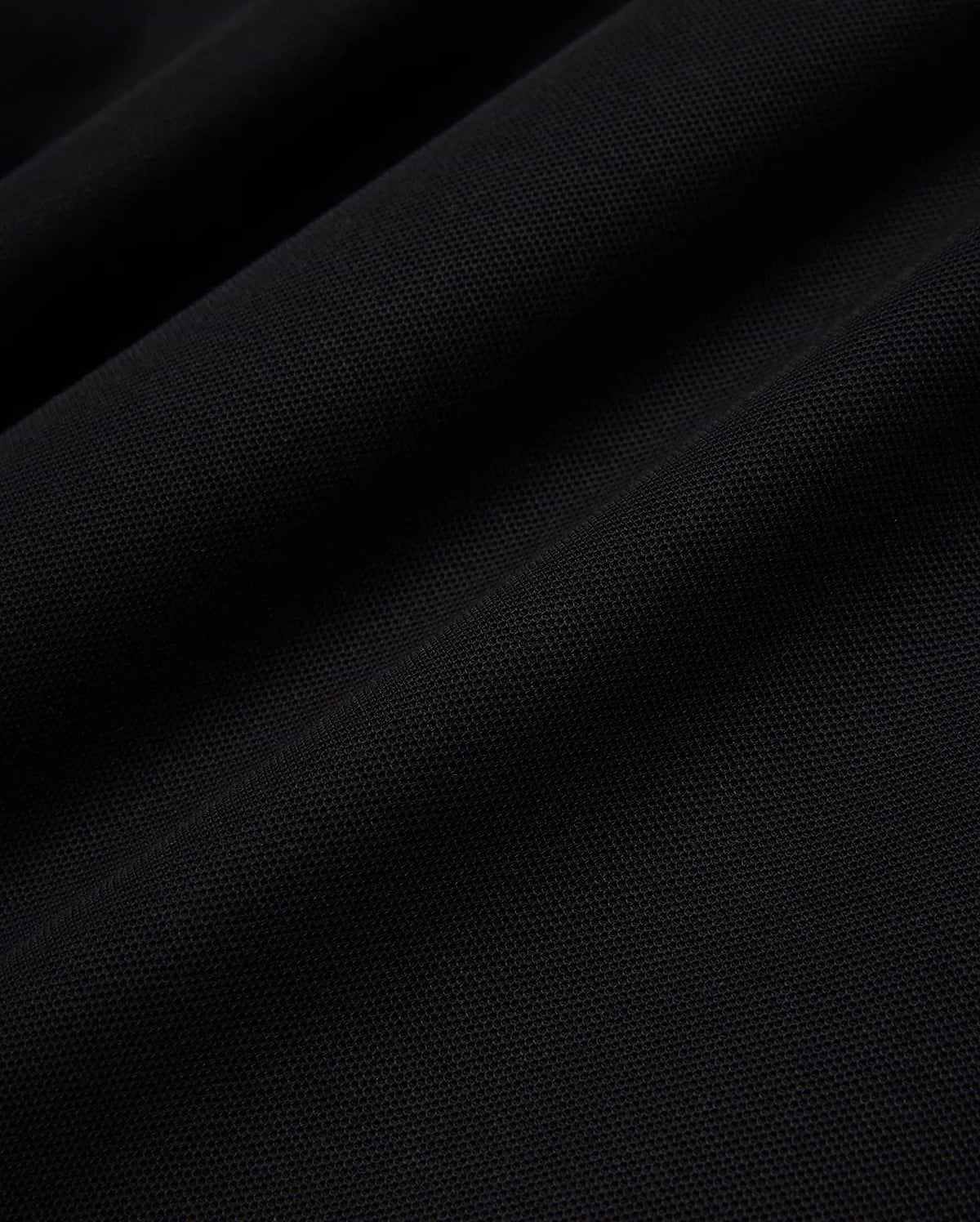 Psycho Bunny Mens Taylor Pique Tee in rich black, highlighting the premium, breathable pique knit fabric texture with subtle, elegant folds and shadows, perfect for refined streetwear.