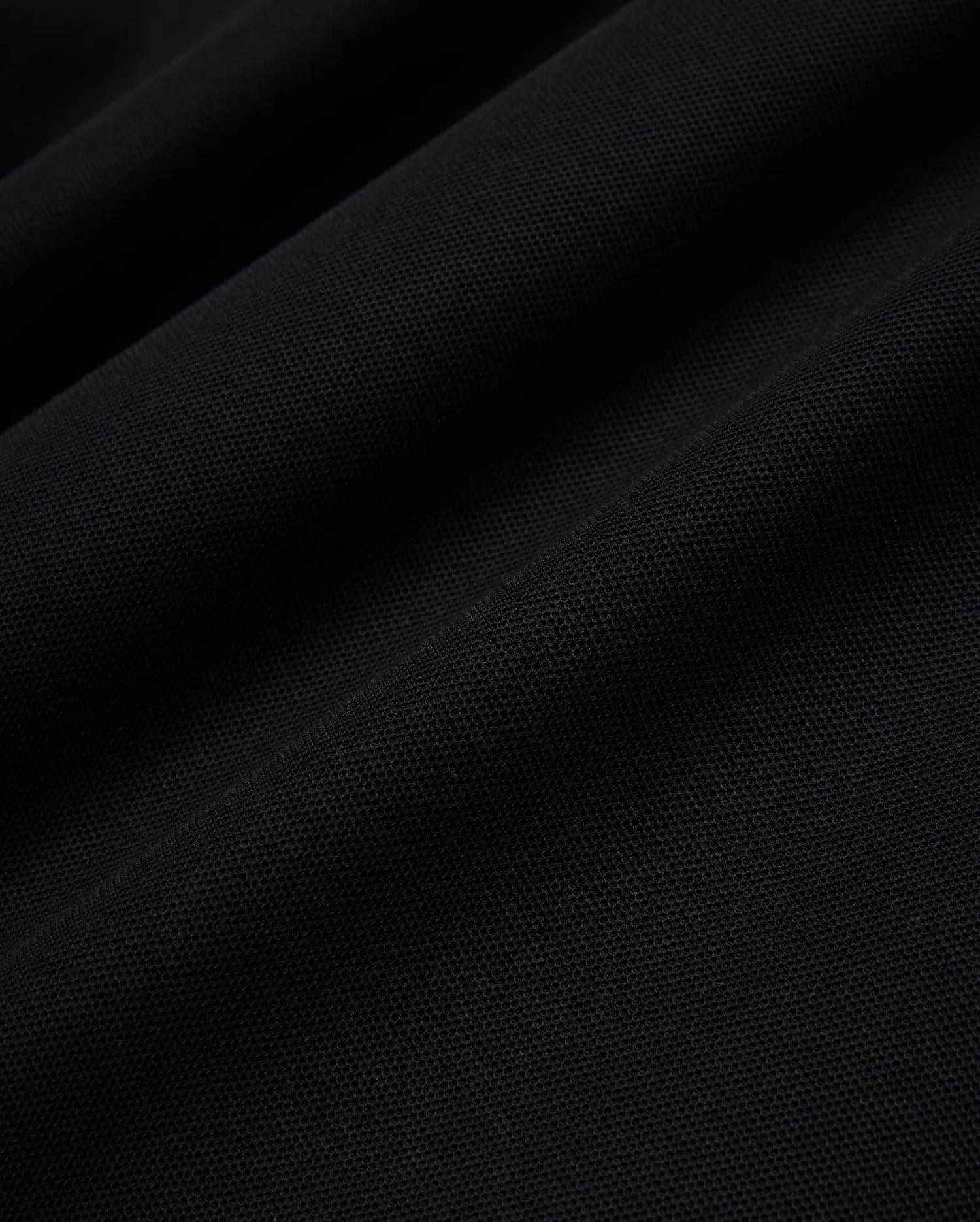 Psycho Bunny Mens Taylor Pique Tee in rich black, highlighting the premium, breathable pique knit fabric texture with subtle, elegant folds and shadows, perfect for refined streetwear.
