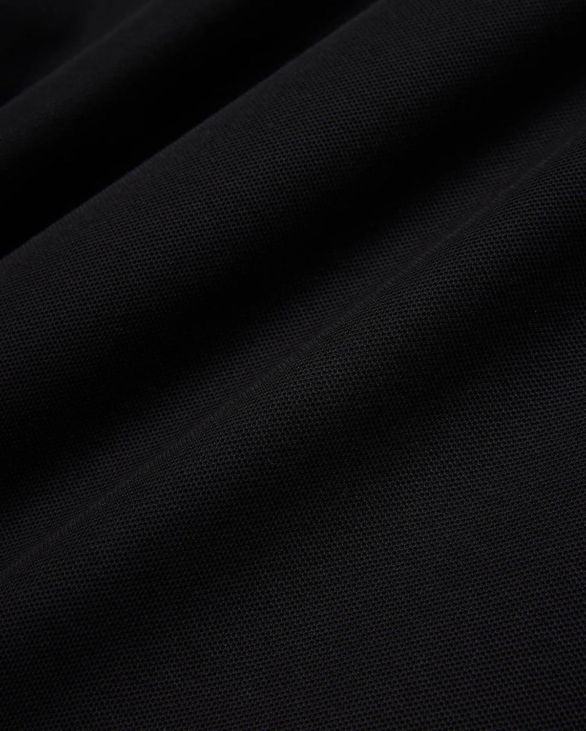 Psycho Bunny Mens Taylor Pique Tee in rich black, highlighting the premium, breathable pique knit fabric texture with subtle, elegant folds and shadows, perfect for refined streetwear.