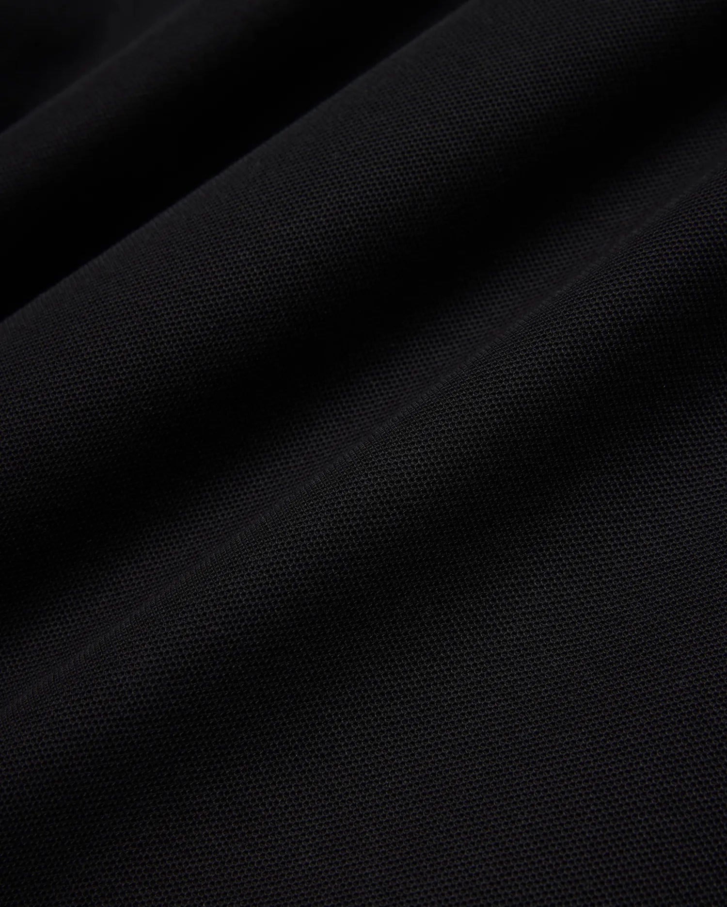 Psycho Bunny Mens Taylor Pique Tee in rich black, highlighting the premium, breathable pique knit fabric texture with subtle, elegant folds and shadows, perfect for refined streetwear.