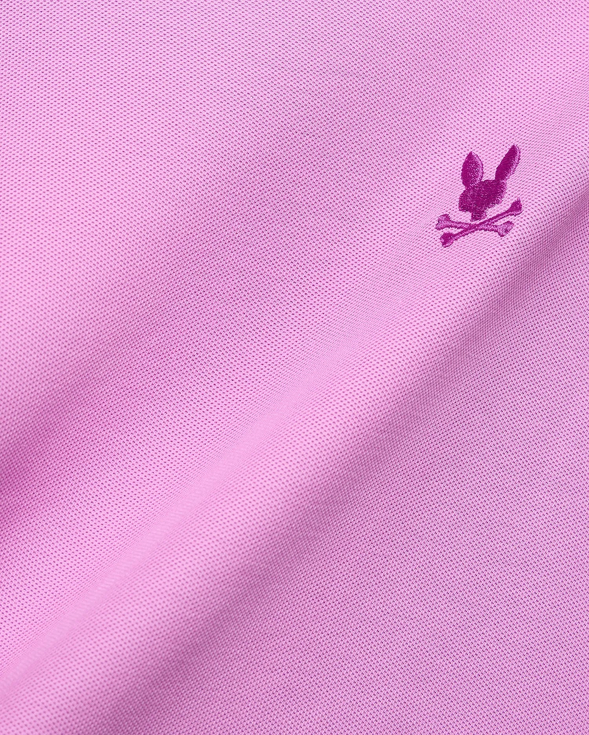 MENS TAYLOR PIQUE TEE in vibrant pink pique knit, featuring a small, intricately embroidered magenta Psycho Bunny skull logo on the chest, embodying refined streetwear style.