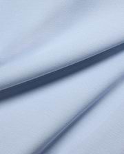 MENS TAYLOR PIQUE TEE in a serene light blue, highlighting the premium, breathable pique fabric with its distinctive textured weave and soft, flowing folds.