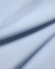 MENS TAYLOR PIQUE TEE in a serene light blue, highlighting the premium, breathable pique fabric with its distinctive textured weave and soft, flowing folds.