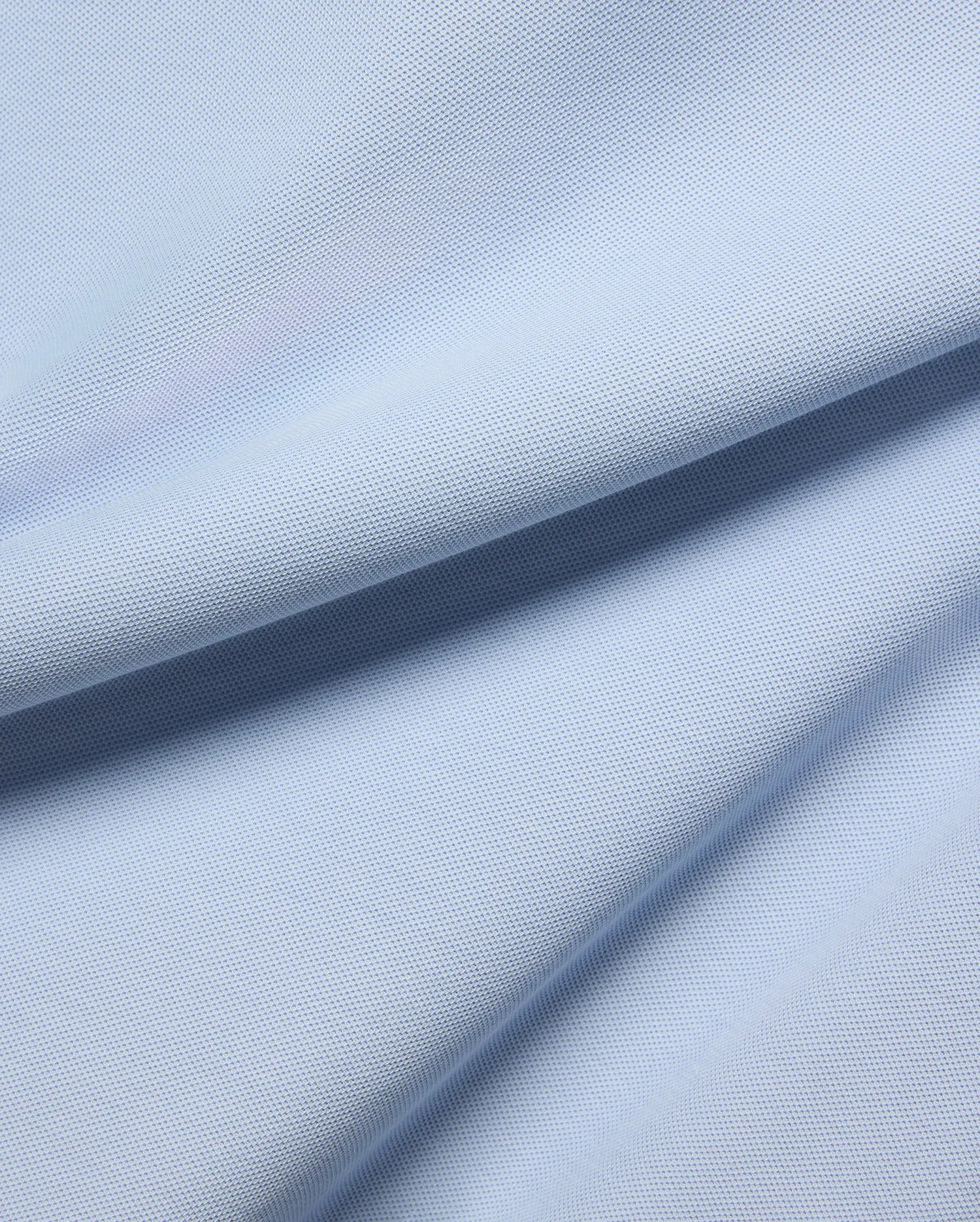 MENS TAYLOR PIQUE TEE in a serene light blue, highlighting the premium, breathable pique fabric with its distinctive textured weave and soft, flowing folds.