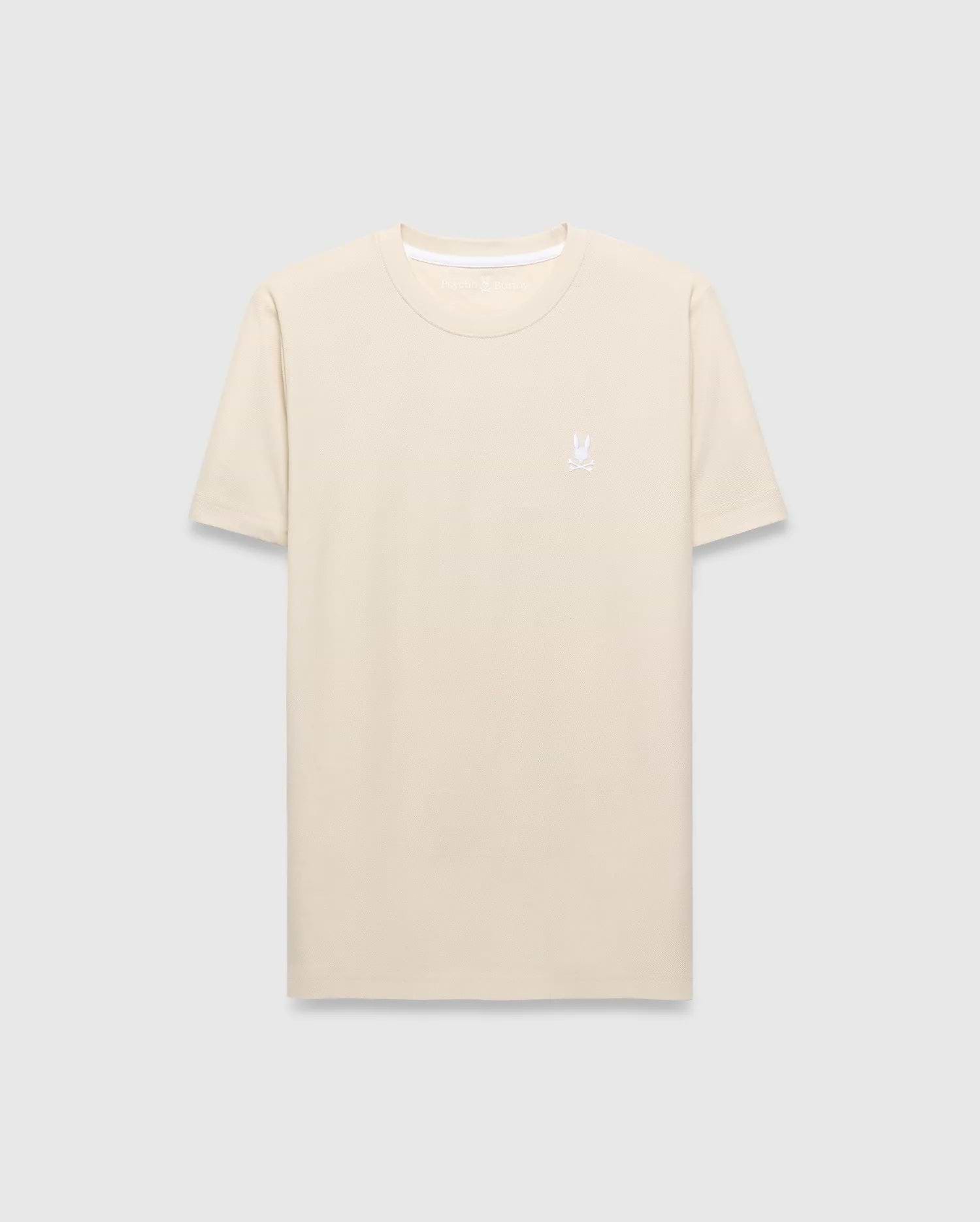 Mens Taylor Pique Tee in cream, featuring a classic fit and subtle pique texture. A small, white embroidered Psycho Bunny skull logo adorns the left chest.