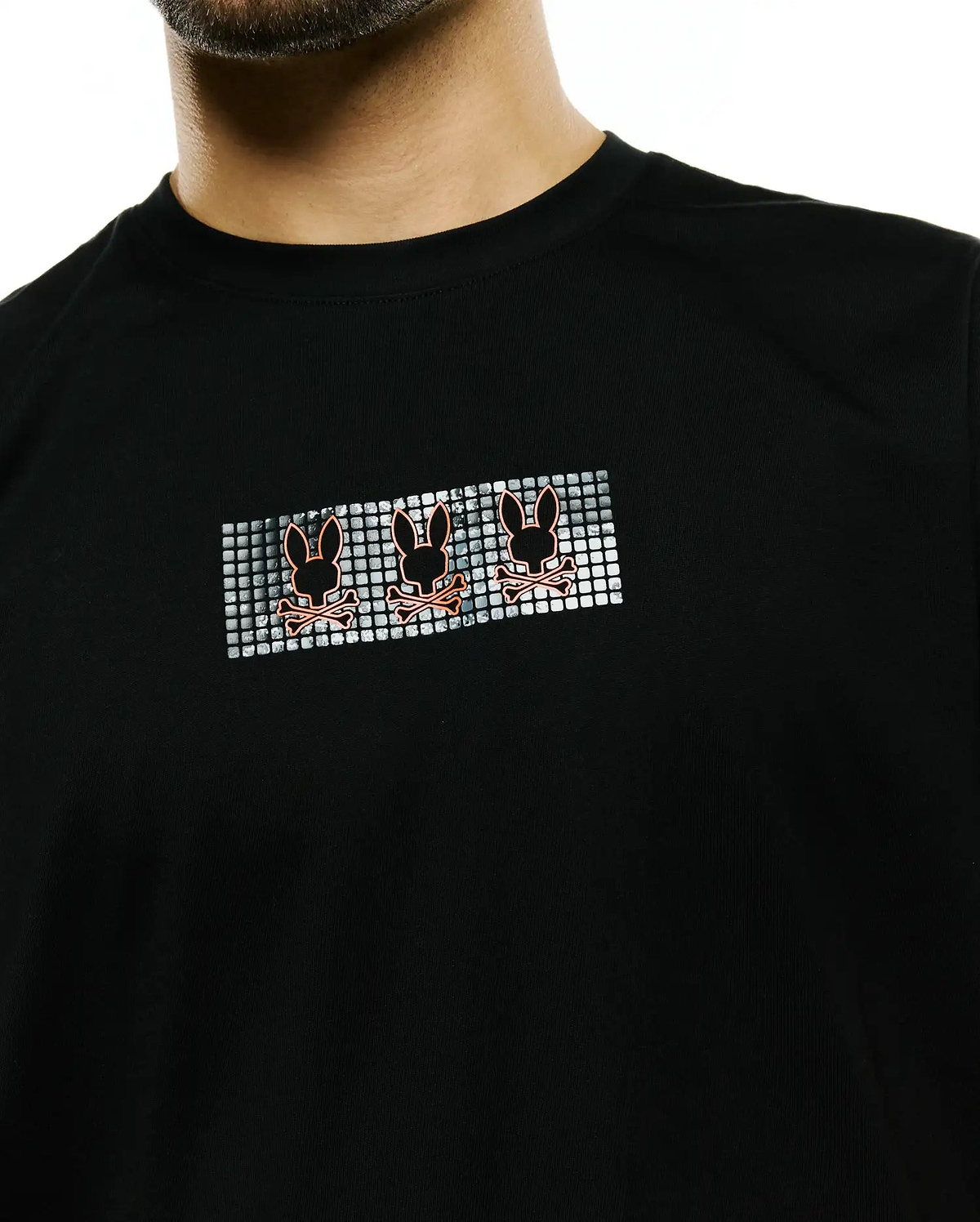 Men's Alfie Back Graphic Tee, black classic fit jersey knit, featuring a chest graphic with three orange Psycho Bunny skull logos on a silver pixelated background. (3)