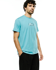Men's Alfie Back Graphic Tee, a classic fit light blue jersey t-shirt with a small rectangular front chest graphic featuring a pixelated Psycho Bunny skull and text. (2)