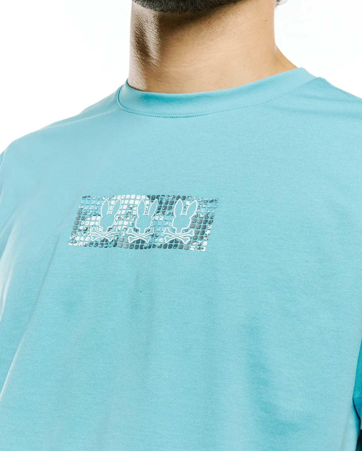 Men's Alfie Back Graphic Tee, aqua blue classic fit jersey knit with a chest graphic featuring three metallic silver Psycho Bunny skull logos on a textured rectangular background. (3)