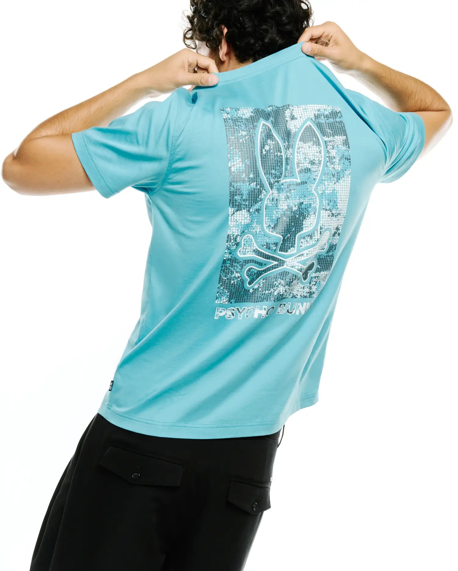 Men's Alfie Back Graphic Tee, a classic fit aqua blue jersey t-shirt with a large back graphic featuring a white-outlined Psycho Bunny skull over a pixelated silver digital camo pattern and PSYCHO BUNNY text. (1)