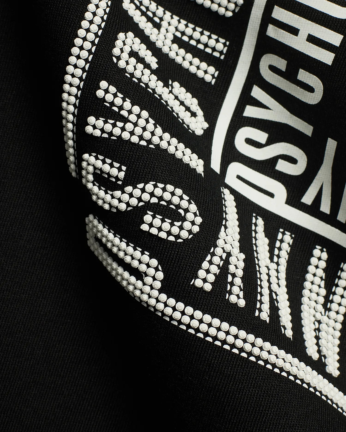 Men's Raj Wordmark Graphic Tee, a black jersey t-shirt featuring a prominent white graphic print with a unique textured dotted effect on parts of the Psycho Bunny wordmark. (6)