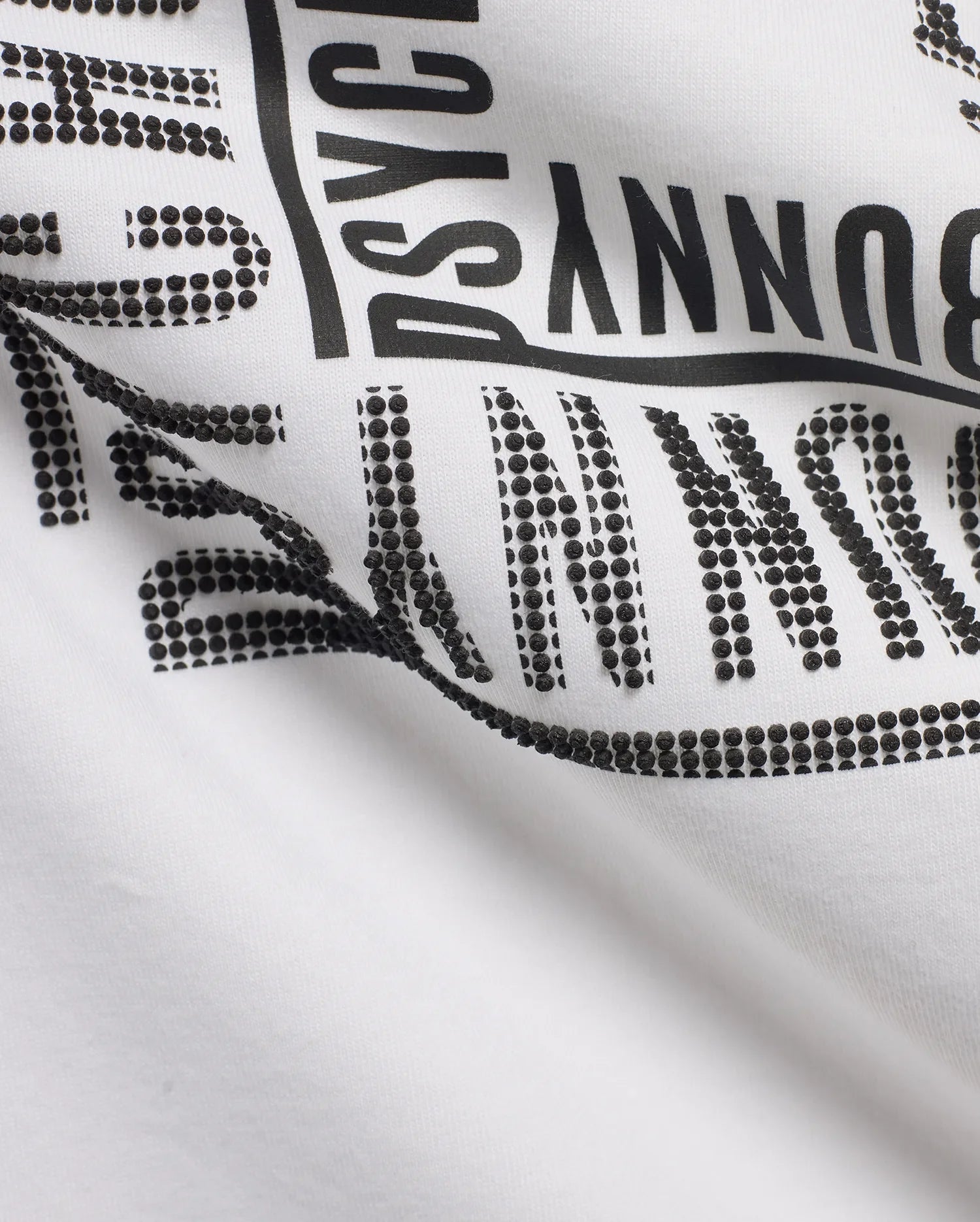 White Men's Raj Wordmark Graphic Tee in jersey knit, featuring a large black Psycho Bunny wordmark with a unique textured design where some letters are solid and others are raised black dots. (7)