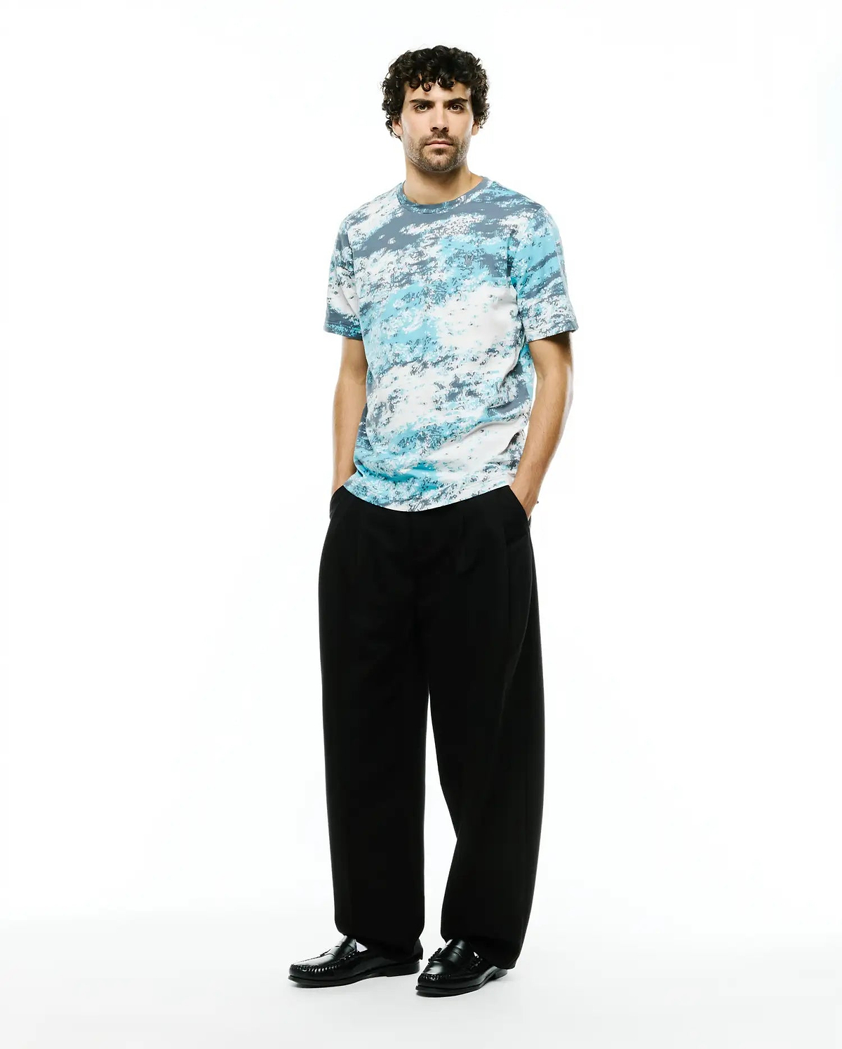 Psycho Bunny Men's Alfie All-Over Jacquard Tee, a premium relaxed fit t-shirt with a soft jersey texture and an abstract blue, white, and grey cloud-like pattern. (4)