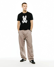 Men's Samson Graphic Tee, a classic fit black jersey t-shirt featuring a large, textured white Psycho Bunny skull and crossbones graphic prominently centered on the chest. (5)
