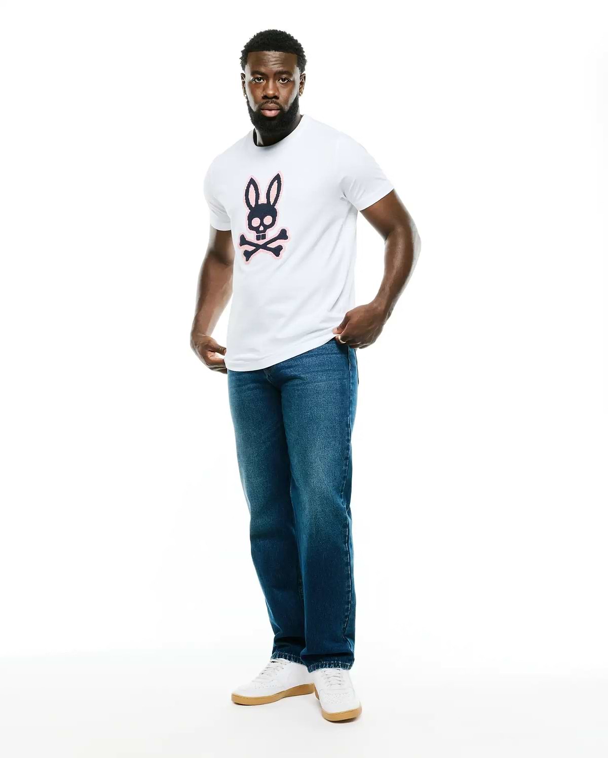 Men's Samson Graphic Tee, a classic fit white jersey t-shirt featuring a large navy and pink Psycho Bunny skull and crossbones graphic on the chest. (5)