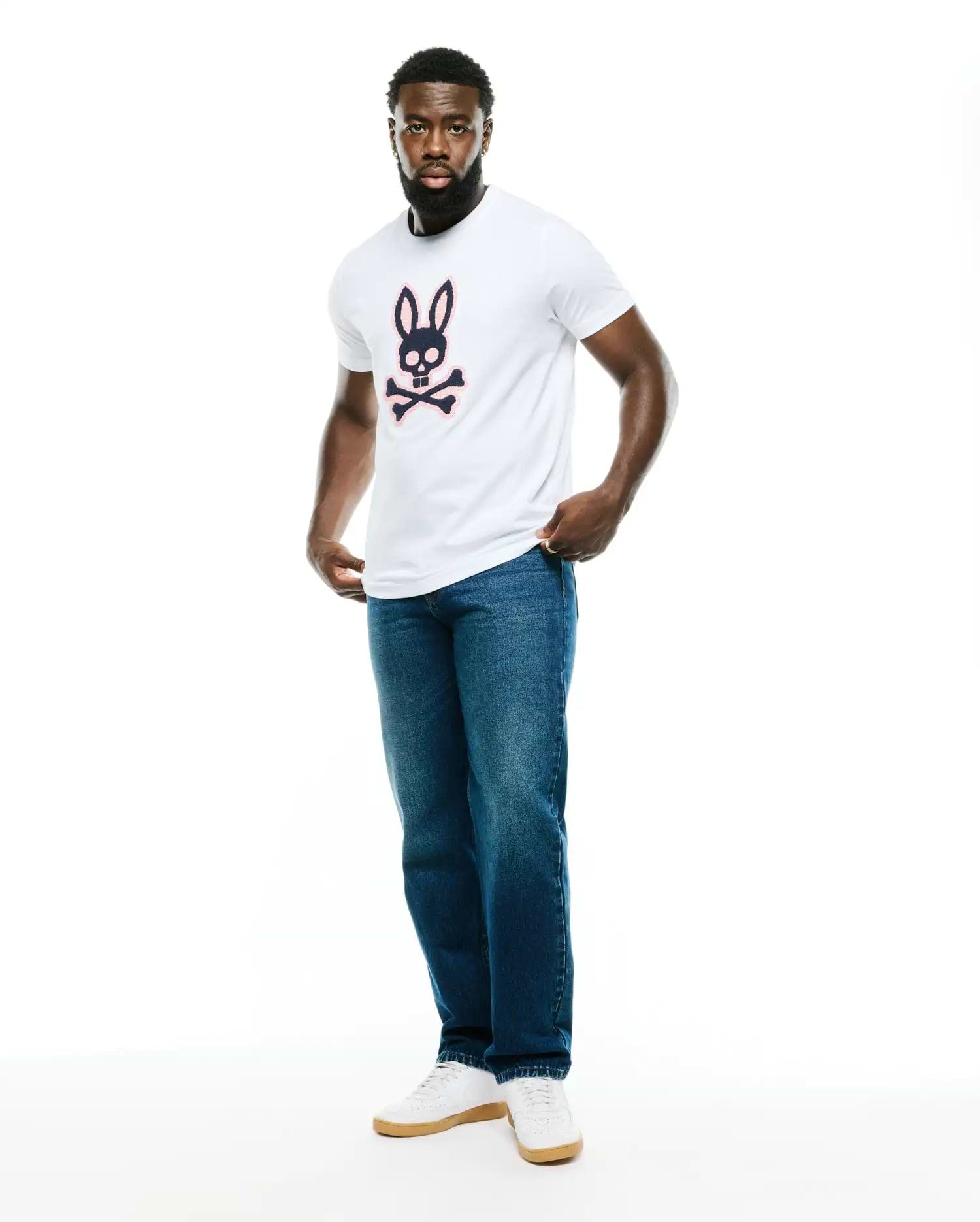 Men's Samson Graphic Tee, a classic fit white jersey t-shirt featuring a large navy and pink Psycho Bunny skull and crossbones graphic on the chest. (5)