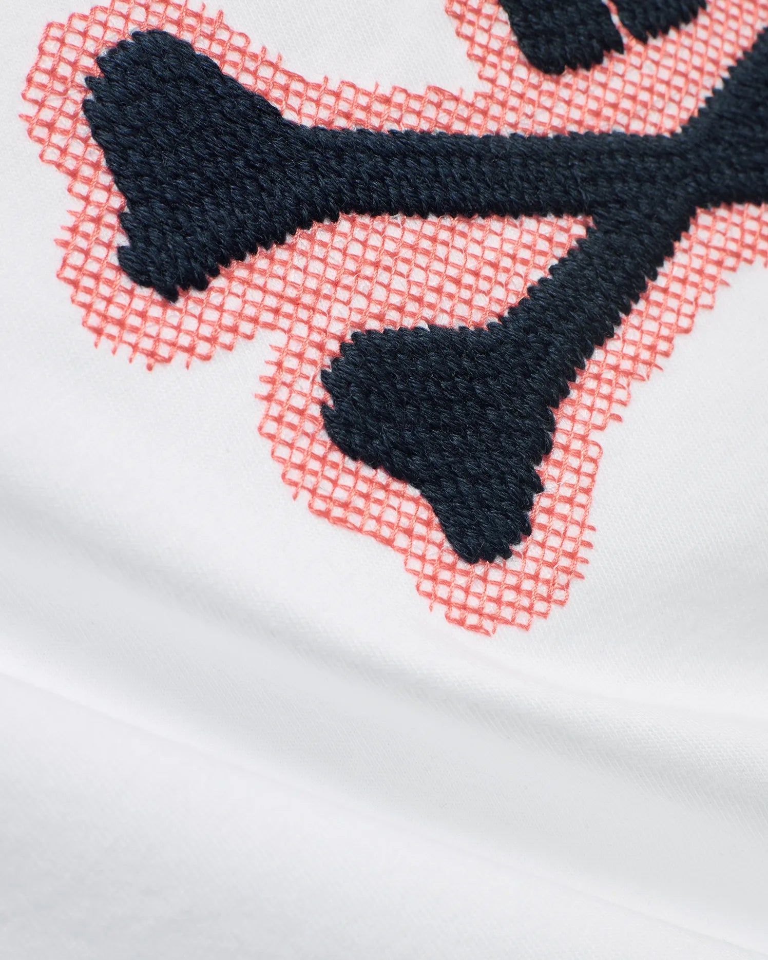 Men's Samson Graphic Tee in white soft jersey, featuring a prominent embroidered dark blue bunny skull logo with a coral cross-stitch outline. (6)