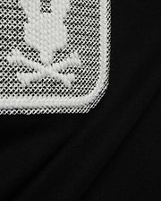 Men's Samson Wordmark Graphic Tee in black, crafted from soft jersey knit. Features a large, textured white embroidered Psycho Bunny skull logo on a white mesh patch. (6)