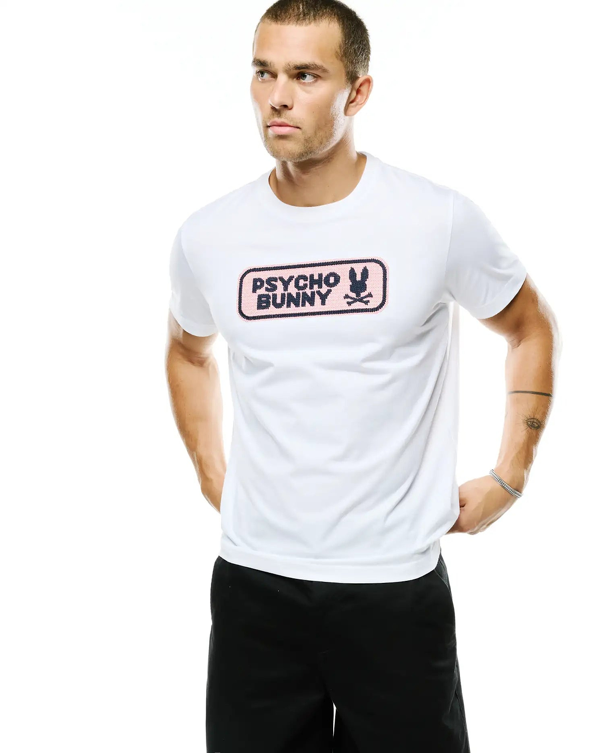 Men's Samson Wordmark Graphic Tee, a classic fit white jersey t-shirt with a prominent chest graphic featuring a pink rectangular background, dark blue Psycho Bunny wordmark, and bunny skull logo. (4)