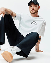 White Mens Stevie Relaxed Fit Tee in smooth jersey, featuring a black arched PSYCHO BUNNY text and iconic bunny skull logo centered on the chest.
