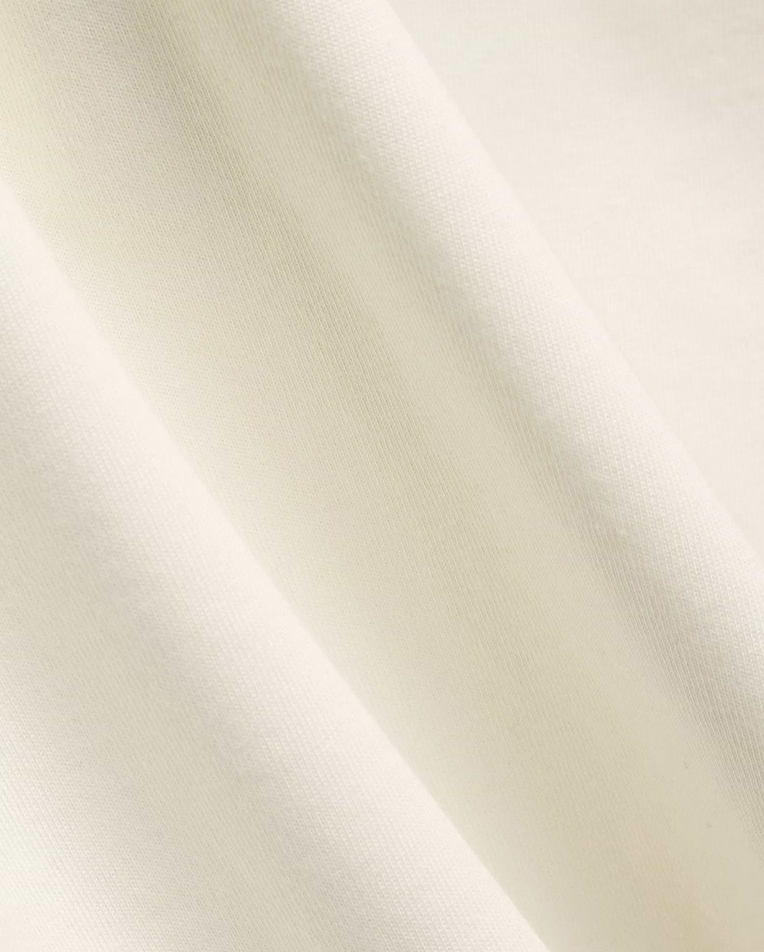 Mens Windcrest Relaxed Fit Tee in a soft, creamy off-white hue, showcasing its premium, smooth fine jersey knit fabric texture with elegant, flowing diagonal folds. (6)