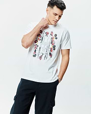 Mens Race Bunny Graphic Tee, a classic fit white jersey t-shirt featuring a vibrant front print of race car drivers, wheels, and a distressed Psycho Bunny skull.