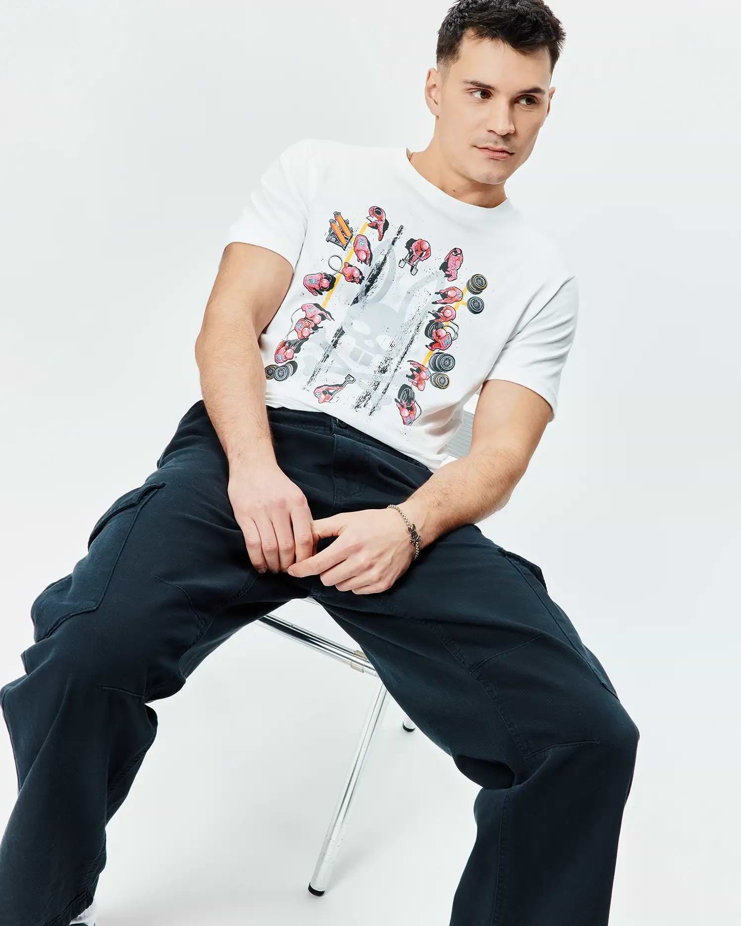 Mens Race Bunny Graphic Tee: White classic fit jersey t-shirt with a large central graphic print featuring colorful race cars, drivers, and a distressed Psycho Bunny skull logo.