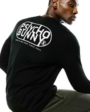 Black Mens Dariel Long Sleeve Back Graphic Tee in soft jersey knit, featuring a large white Psycho Bunny oval graphic on the back with Made In New York Since 2005 text and the iconic bunny skull logo.