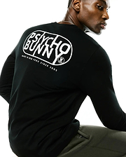 Black Mens Dariel Long Sleeve Back Graphic Tee in soft jersey knit, featuring a large white Psycho Bunny oval graphic on the back with Made In New York Since 2005 text and the iconic bunny skull logo.
