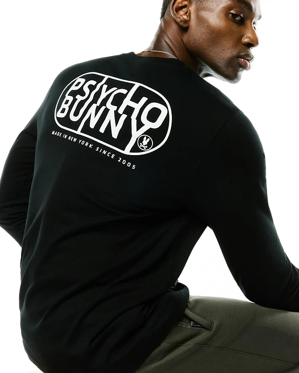 Black Mens Dariel Long Sleeve Back Graphic Tee in soft jersey knit, featuring a large white Psycho Bunny oval graphic on the back with Made In New York Since 2005 text and the iconic bunny skull logo.