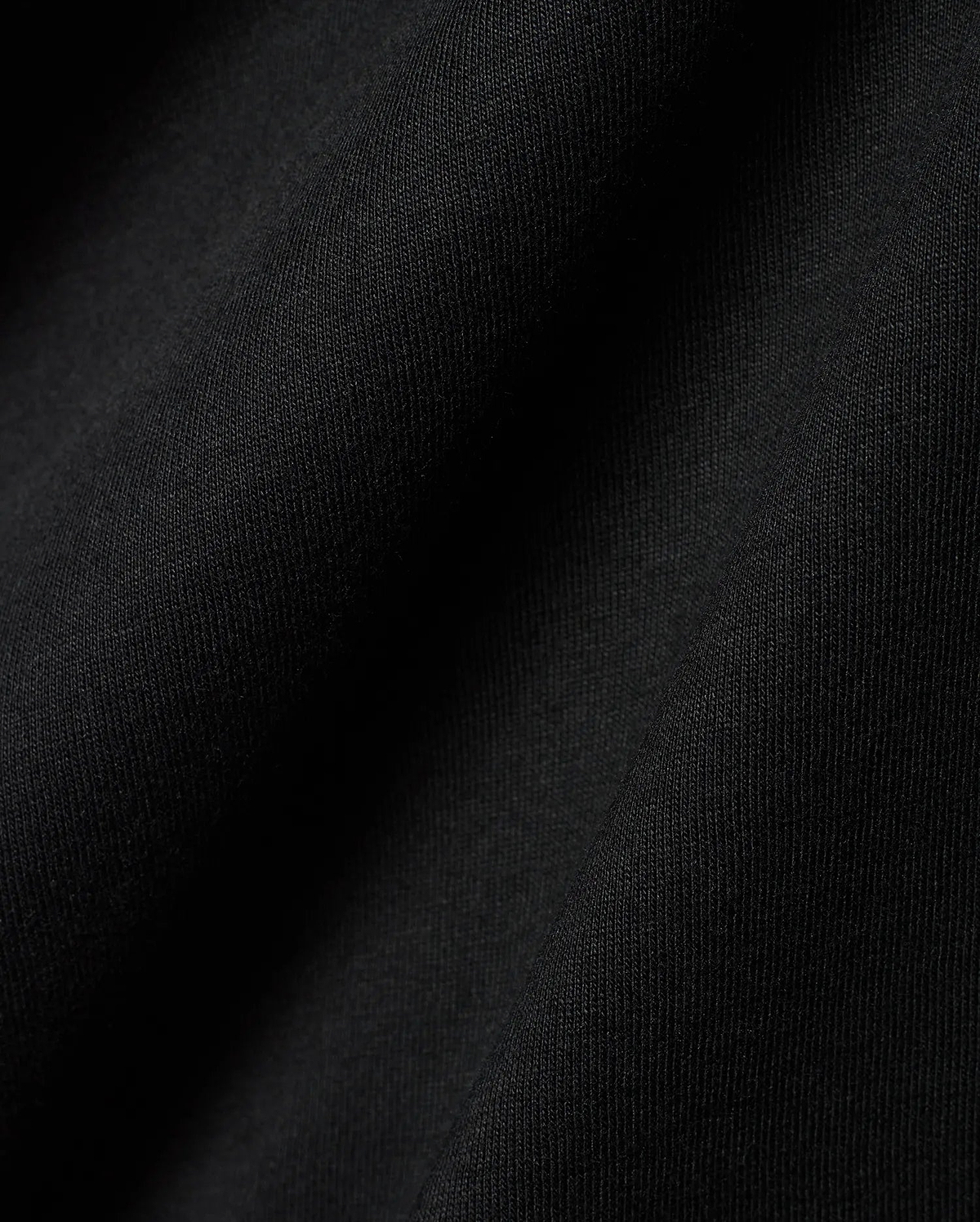 Black Mens Dariel Long Sleeve Back Graphic Tee, crafted from premium, soft jersey knit fabric with subtle vertical texture and elegant folds, reflecting refined streetwear quality.