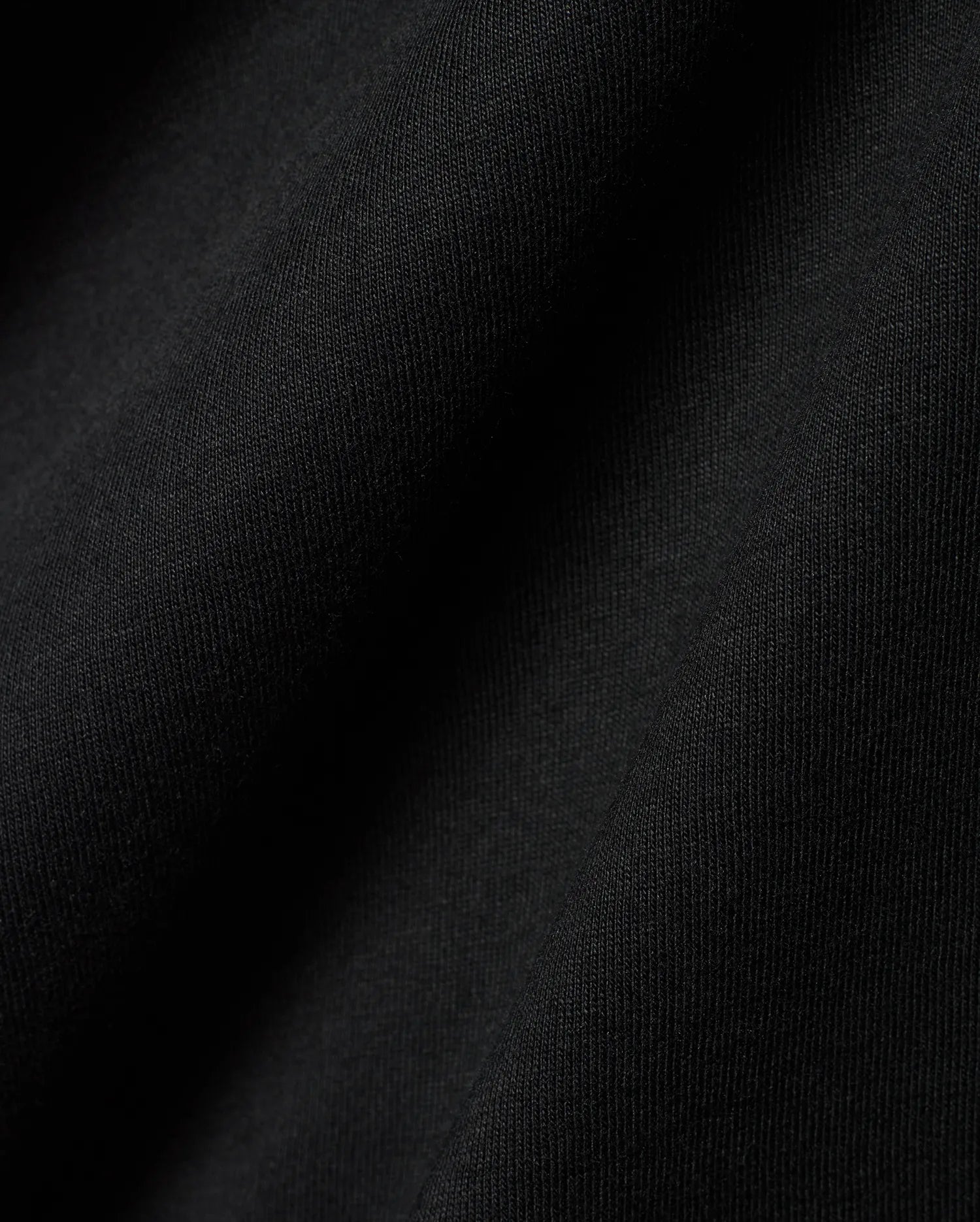Black Mens Dariel Long Sleeve Back Graphic Tee, crafted from premium, soft jersey knit fabric with subtle vertical texture and elegant folds, reflecting refined streetwear quality.