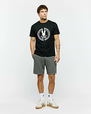 Mens Santa Fe Bunny Graphic Tee, a black classic fit premium jersey t-shirt featuring a large white circular Psycho Bunny skull logo graphic on the chest, complemented by grey textured knit drawstring shorts with a cuffed hem.
