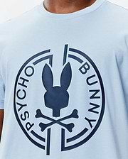 Mens Santa Fe Bunny Graphic Tee, a light blue jersey knit t-shirt with a classic fit, featuring a large navy Psycho Bunny skull and crossbones logo graphic on the central chest, encircled by PSYCHO BUNNY text. (3)