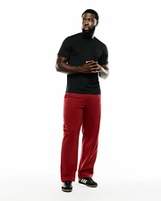 Men's Edmonds Chest Bunny Sport Tee, a black jersey t-shirt with a small red embroidered Psycho Bunny skull on the left chest and red sleeve trim, paired with relaxed fit red pants. (4)