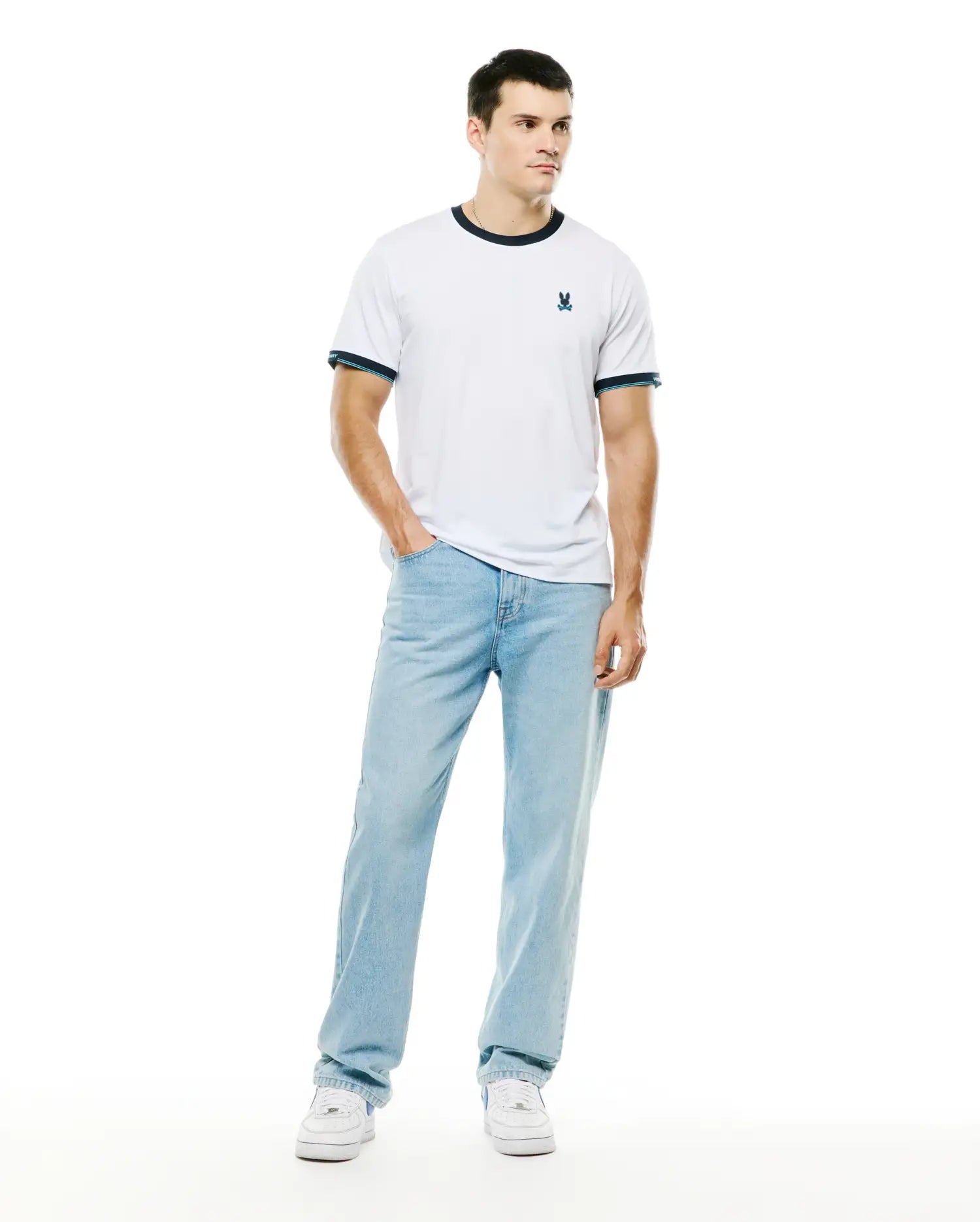 Men's Edmonds Chest Bunny Sport Tee, a classic fit white jersey ringer t-shirt with navy blue ribbed collar and cuffs featuring a light blue stripe, and a small embroidered Psycho Bunny skull logo on the left chest. (4)