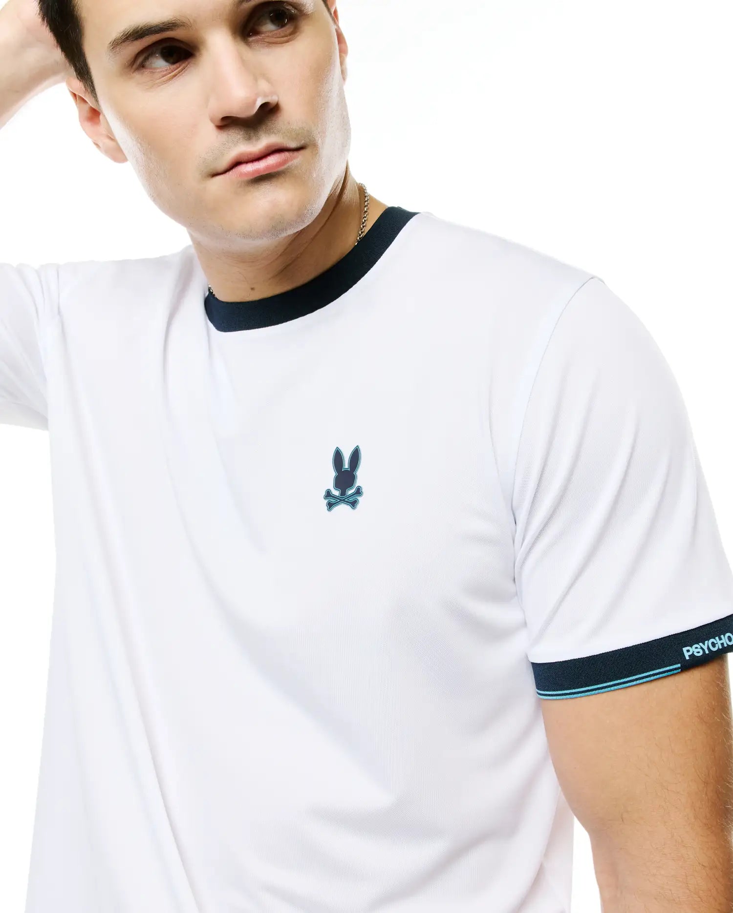 Men's Edmonds Chest Bunny Sport Tee, white performance jersey with navy ringer collar and sleeve cuffs, light blue stripes, embroidered chest bunny skull logo, and PSYCHO BUNNY text on cuff. (3)