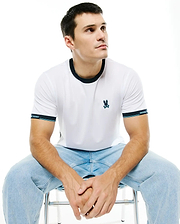 Men's Edmonds Chest Bunny Sport Tee: White jersey t-shirt with a dark blue ringer collar, banded sleeves featuring light blue stripes and Psycho Bunny text, and an embroidered teal bunny skull logo on the chest. (1)