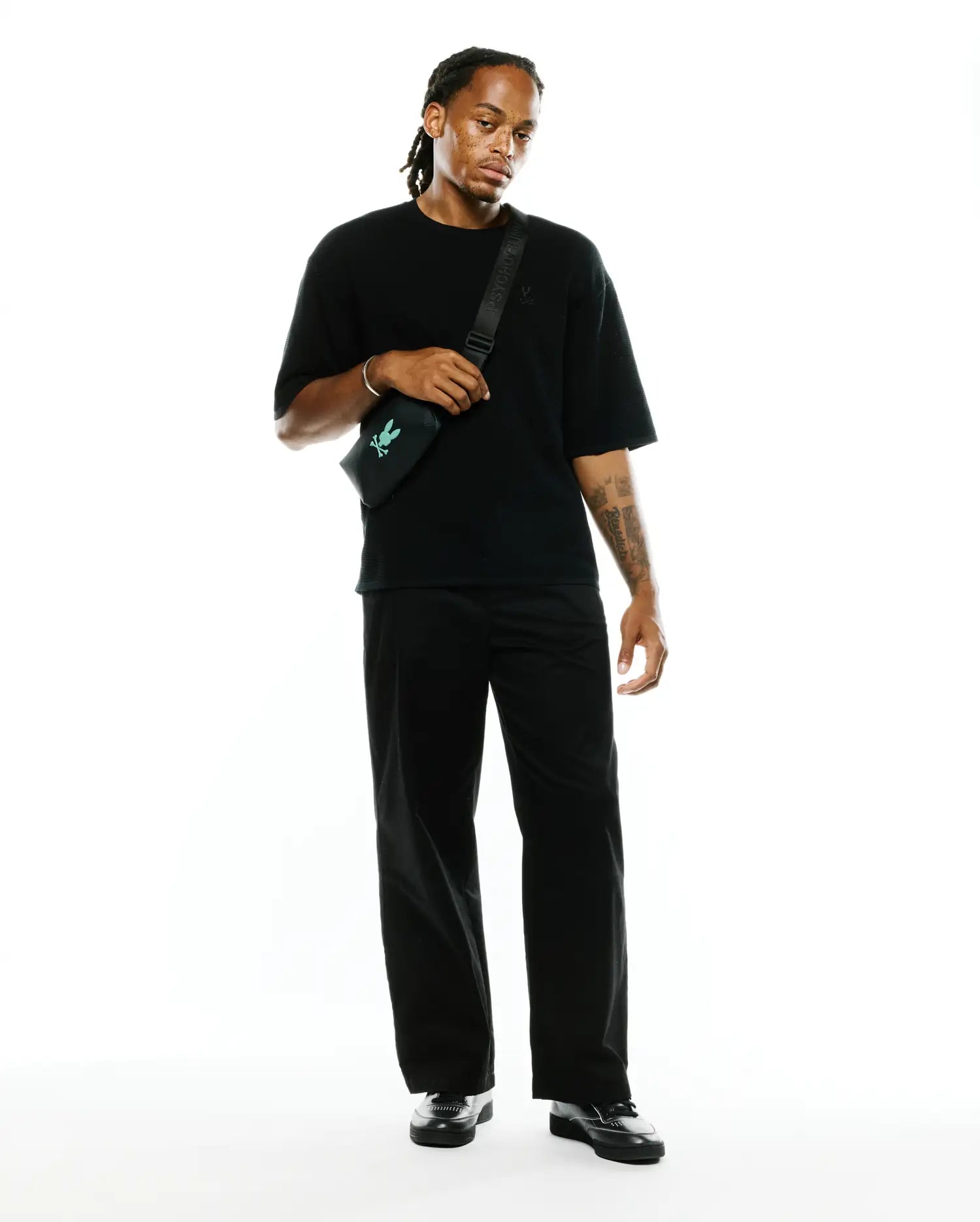 Black Mens Makai Textured Knit T-Shirt with a relaxed fit, featuring a subtle textured knit fabric and a small embroidered Psycho Bunny skull logo on the left chest.
