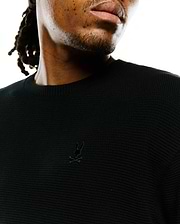 Mens Makai Textured Knit T-Shirt in black, showcasing a classic fit, prominent textured knit fabric, and a small, tonal embroidered Psycho Bunny skull logo on the left chest.
