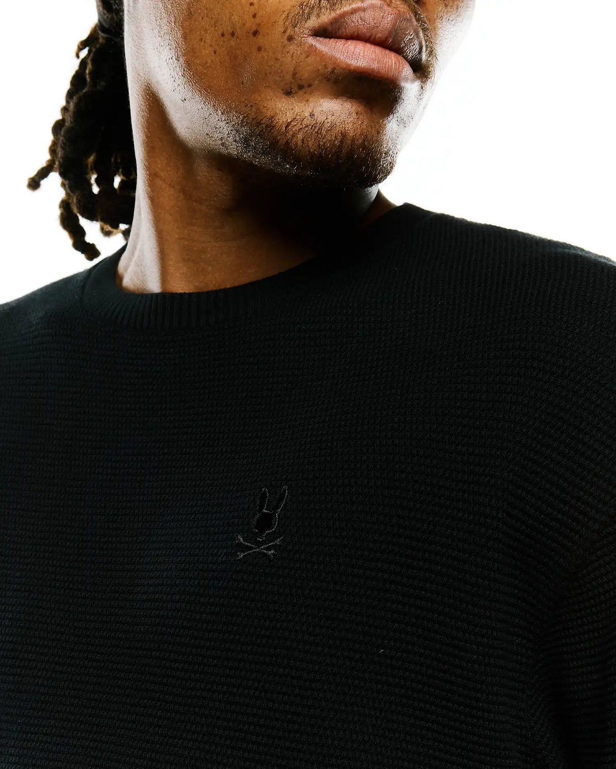 Mens Makai Textured Knit T-Shirt in black, showcasing a classic fit, prominent textured knit fabric, and a small, tonal embroidered Psycho Bunny skull logo on the left chest.