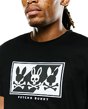 Mens Desmond Graphic Tee, black classic fit jersey, featuring a large chest graphic with three stylized white and black Psycho Bunny skull logos in a checkerboard pattern, bordered by white embroidery and Psycho Bunny text.