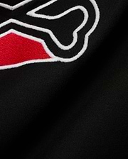 Men's Lowell Graphic Tee in classic black jersey knit, showcasing a prominent, textured embroidered graphic with vibrant red fill and a sharp white outline, embodying refined streetwear. (6)