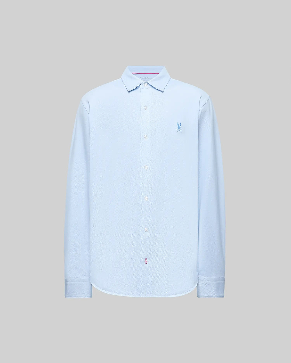 The Psycho Bunny MENS JIM JERSEY STRIPED KNIT SHIRT (MT0300041) is a light blue, long-sleeve, collared button-up with a subtle logo on the left chest, made from soft cotton jersey and shown against a plain gray background.