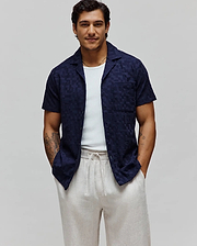 Mens Josh Jacquard Shirt, a navy blue short-sleeve camp collar shirt with a relaxed fit and subtle tonal jacquard weave featuring integrated Psycho Bunny skull logos.