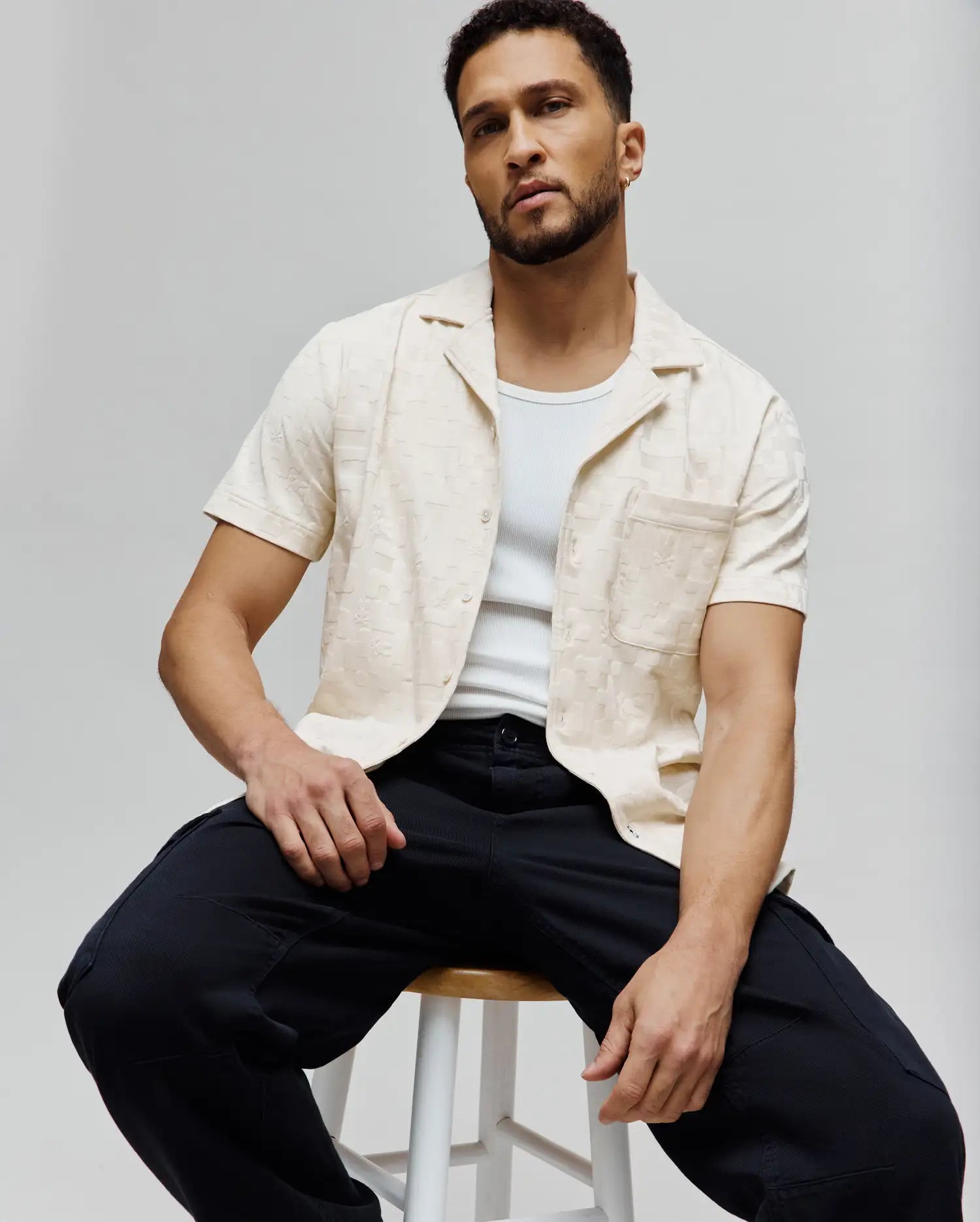 Mens Josh Jacquard Shirt, a relaxed fit cream short-sleeve button-up with a subtle all-over Psycho Bunny skull jacquard pattern, camp collar, and left chest pocket.