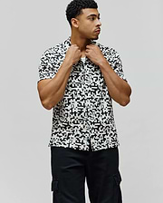 Mens Josh Jacquard Shirt, a classic fit short-sleeve button-up, in white with an all-over black geometric pixelated pattern subtly incorporating the iconic Psycho Bunny skull logo.