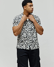 Mens Josh Jacquard Shirt, a classic fit short-sleeve button-up, in white with an all-over black geometric pixelated pattern subtly incorporating the iconic Psycho Bunny skull logo.