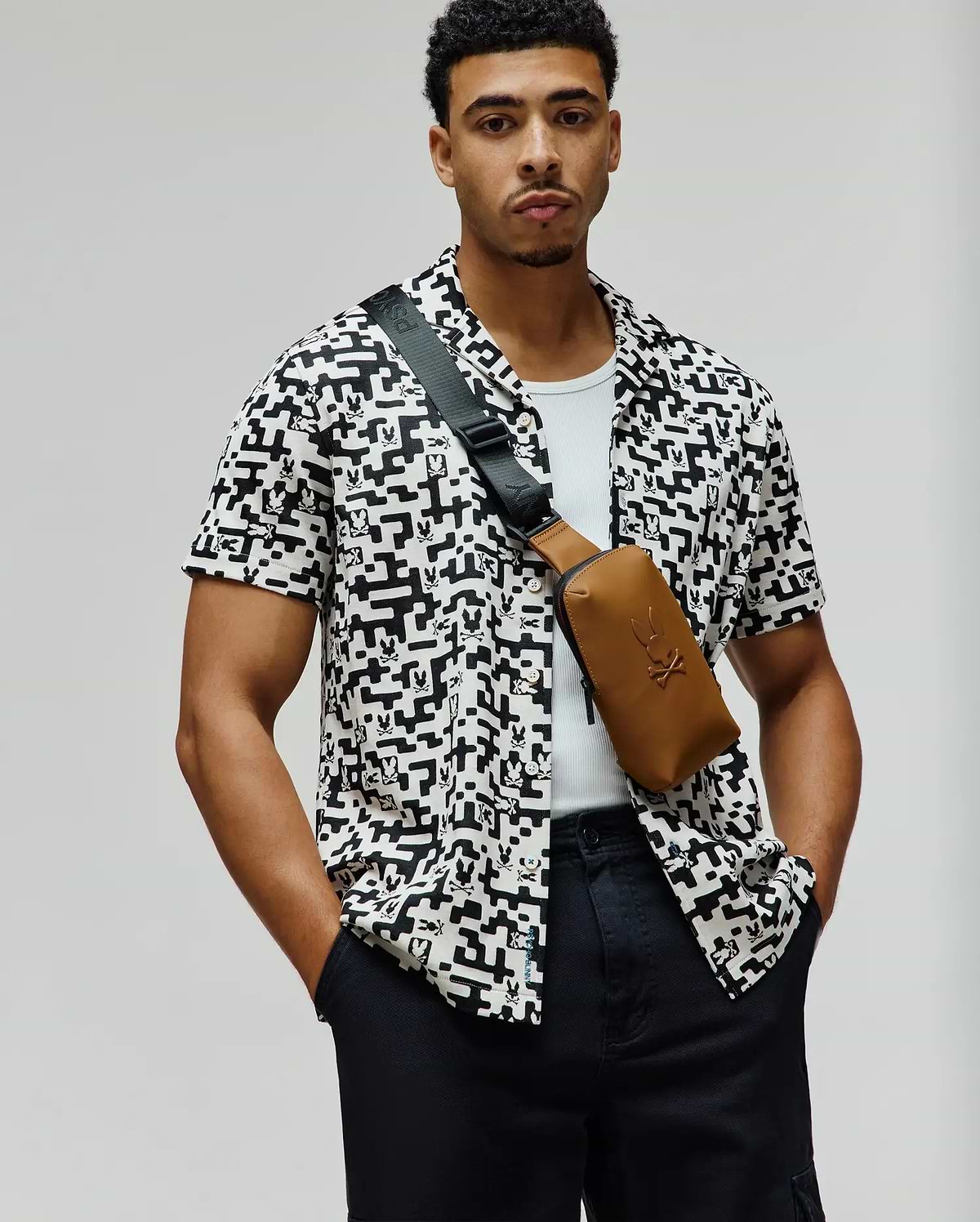 Mens Josh Jacquard Shirt, a relaxed fit white short-sleeve button-up with an all-over black geometric and small Psycho Bunny skull logo jacquard pattern.