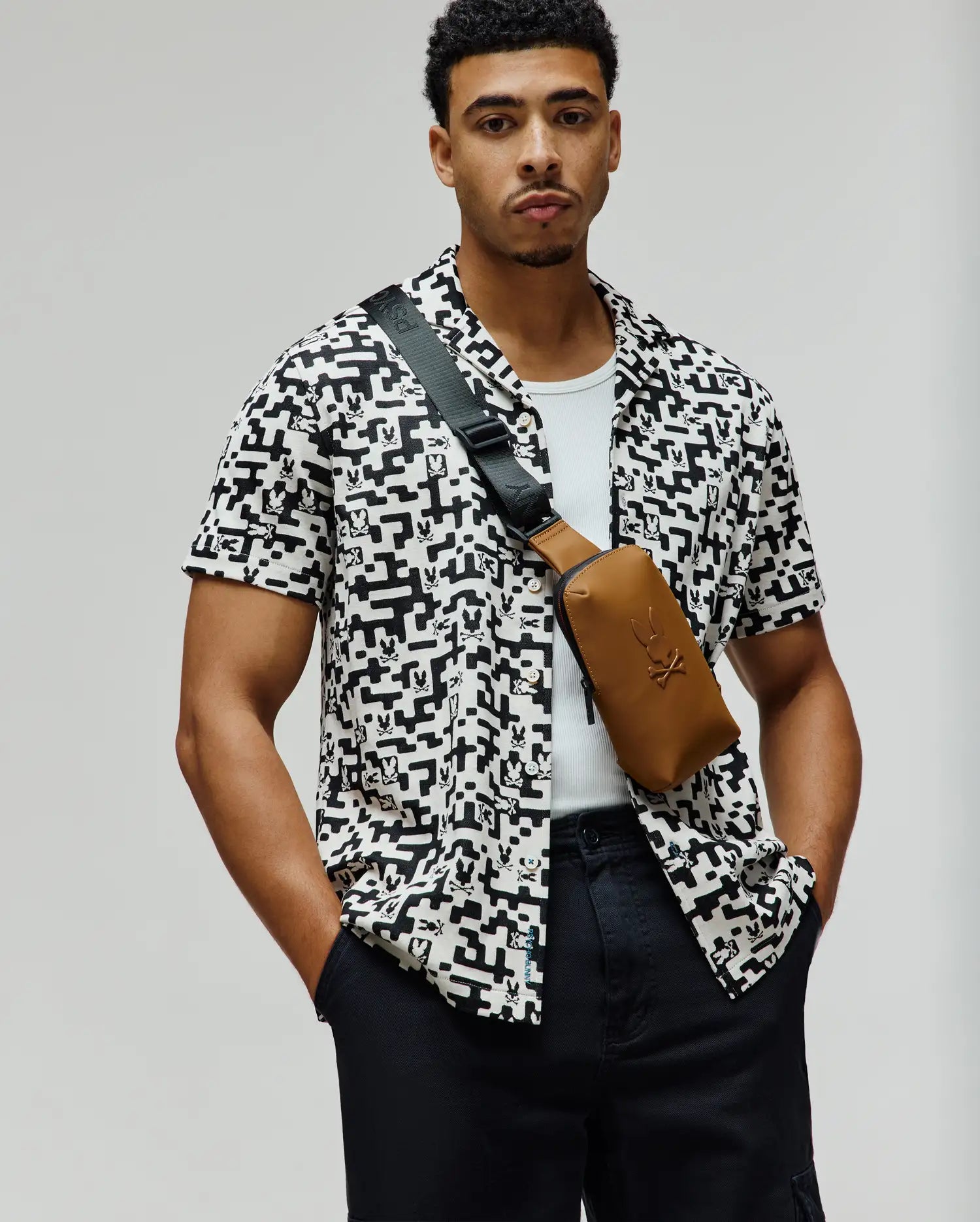 Mens Josh Jacquard Shirt, a relaxed fit white short-sleeve button-up with an all-over black geometric and small Psycho Bunny skull logo jacquard pattern.